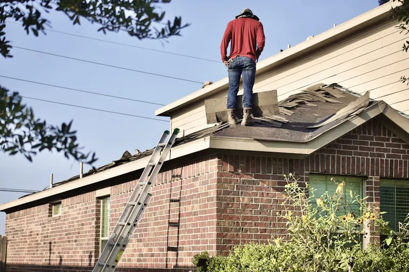Professional roofer working on a residential roof in Lower Roxbury